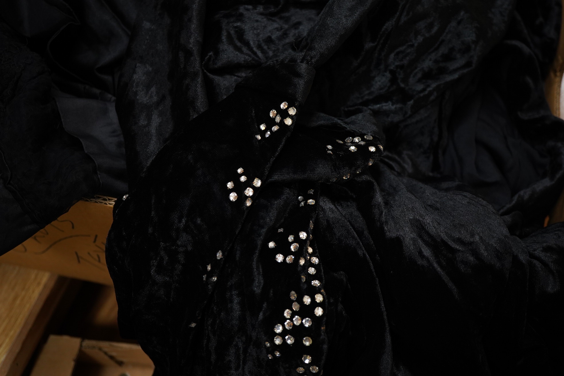 Two Edwardian blouses and three earlier lace camisoles, three black satin partly sewn skirts and later black velvet diamonte decorated evening coat. Condition - the coat, skirts and blouses need repair but are good for T